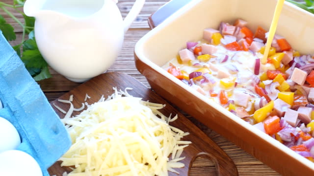 Preparation of omelet with ham and cheese before being baked.