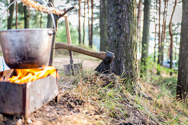 teapot with food on  brazier, the axe in  tree outdoors - wood axe imagens e fotografias de stock