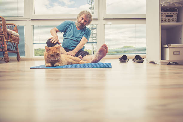 istock Senior Man exercising at Home with his Ginger Cat 628799344