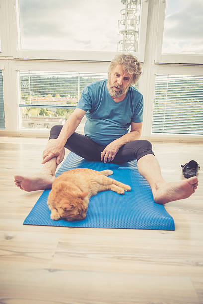 istock Senior Man exercising at Home with his Ginger Cat 628800130