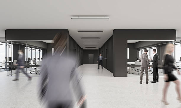 istock People walking in office with black and glass walls 628800278