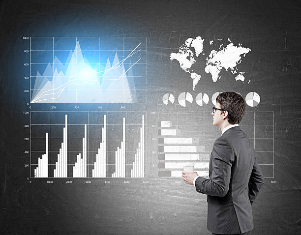 istock Side view of a bespectacled businessman looking at graphs 628800966