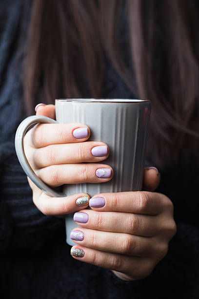 istock Woman with beautiful manicure holding a gray cup of tea 628801310