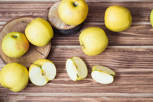 Golden ripe apples on a wooden background