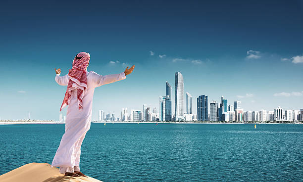 sheik prayiong against the Abu dhabi skyline waterfront