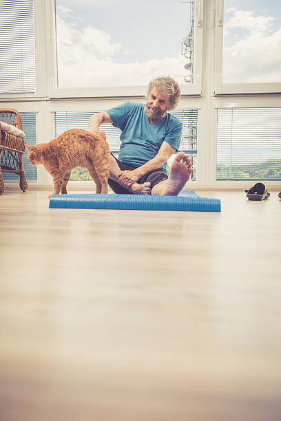 istock Senior Man exercising at Home with his Ginger Cat 628811056