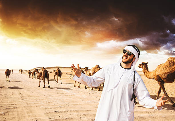 ラクダと一緒に歩く砂漠のアラビア語のシェイク - united arab emirates middle eastern ethnicity men camel ストックフォトと画像