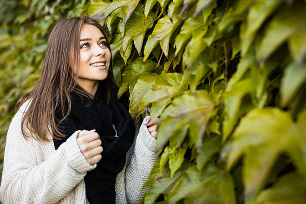 istock brunette girl outdoors on green leaves background 628811662