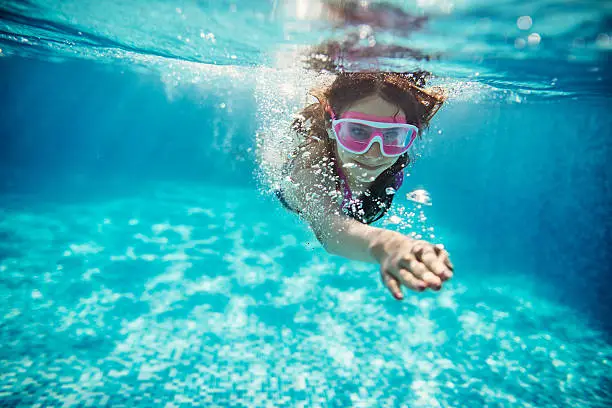 Teenage girl swimming crawl. Shot from underwater. 