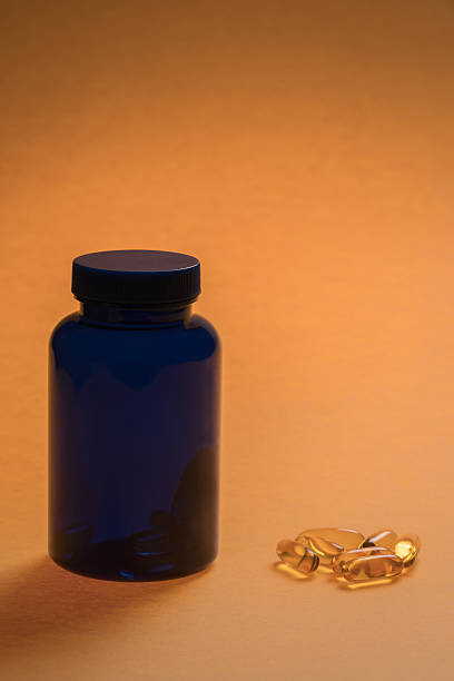 close-up de cápsulas ômega 3 e garrafa - fish oil coq10 vitamin e cod liver oil - fotografias e filmes do acervo