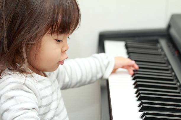 istock Japanese girl playing a piano (2 years old) 628813528