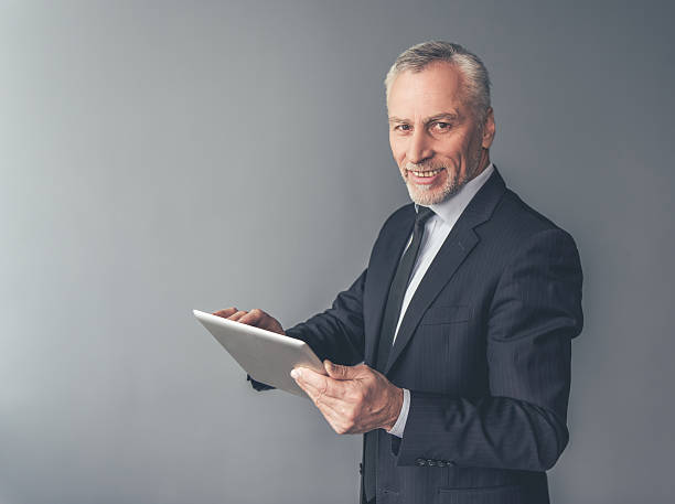 istock Handsome mature businessman with gadget 628814374