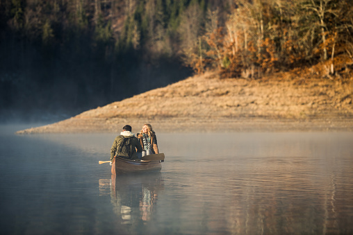 Couple enjoying a winter canoe ride on the lake.