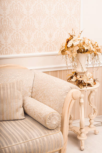 istock White classical sofa close-up and vase with golden branches and 628816314