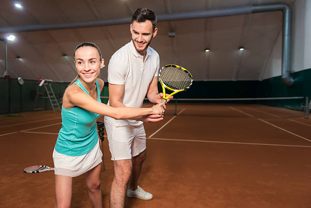 istock Positive friends learning to play tennis 628816908