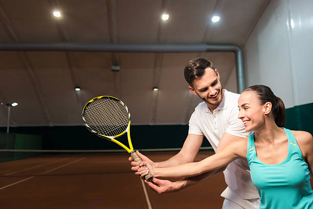 istock Positive instructor teaching to play tennis 628818318