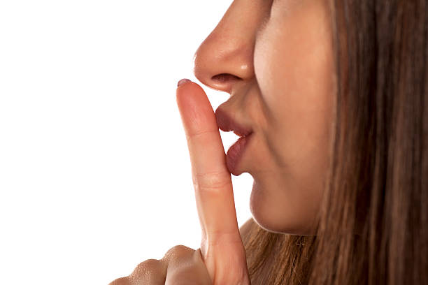 istock finger to her lips. concept for silence 628818446