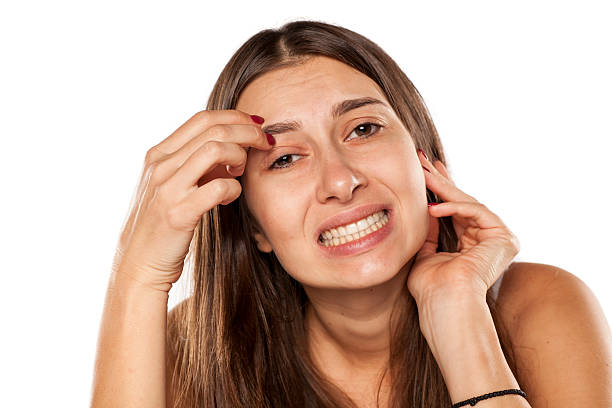 nervous young woman has an itch in eyebrows stock photo