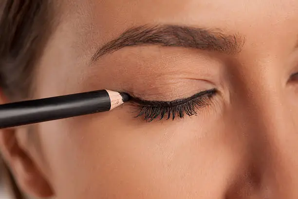 Photo of young woman applied eyeliner