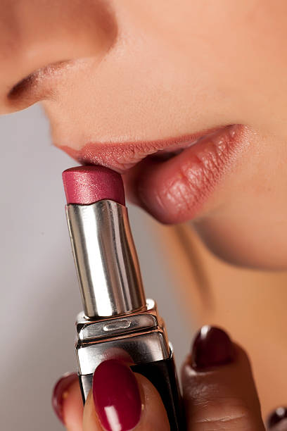 istock young woman applied lipstick on her lips 628818664