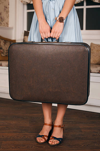 istock Female hands with wrist watch hold a suitcase. 628819580