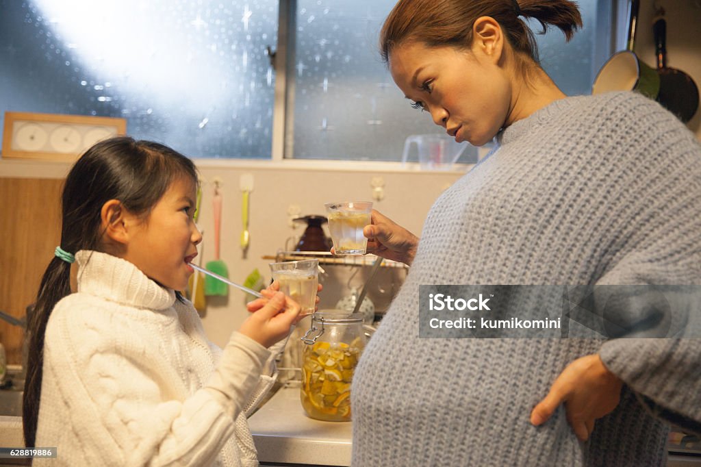 Schwangere Mutter macht Trinken mit ihrer Tochter in ihrer Küche - Lizenzfrei 6-11 Monate Stock-Foto