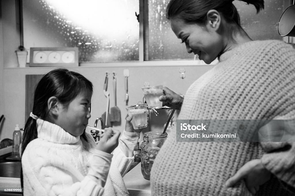 Pregnant mother making drink with her daughter in her kitchen 6-11 Months Stock Photo