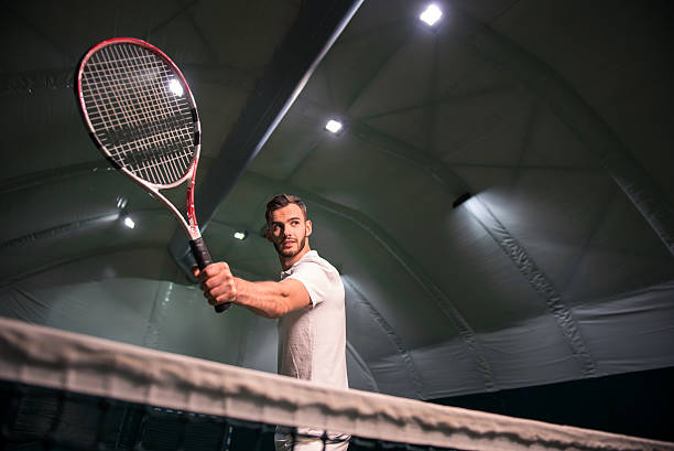 Pleasant handsome sportsman playing tennis