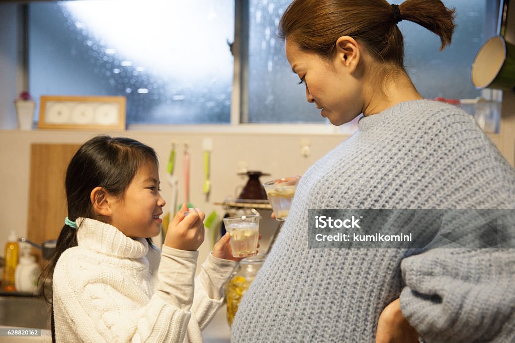 Pregnant mother making drink with her daughter in her kitchen 6-11 Months Stock Photo