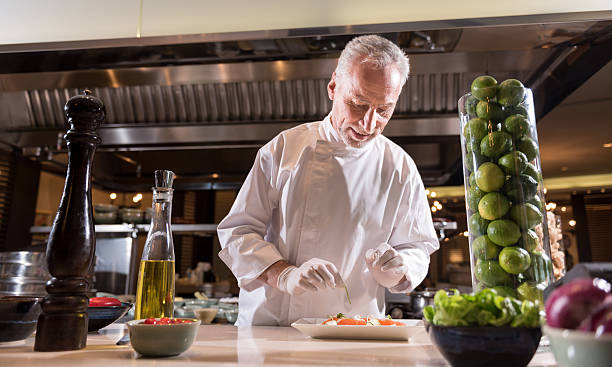 istock Smiling chef decorating the dish in the kitchen 628822766