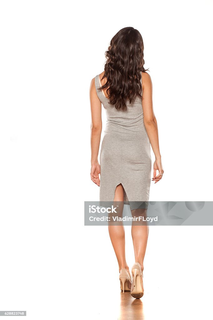 walking in a short dress and high heels back view of a young pretty woman walking in a short dress and high heels Rear View Stock Photo