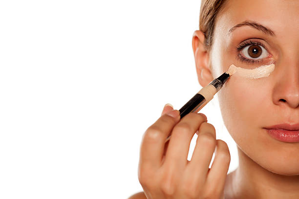 istock young beautiful woman applied concealer under the eyes 628835422