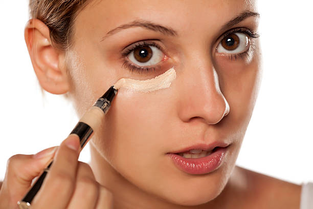 istock young beautiful woman applied concealer under the eyes 628835436