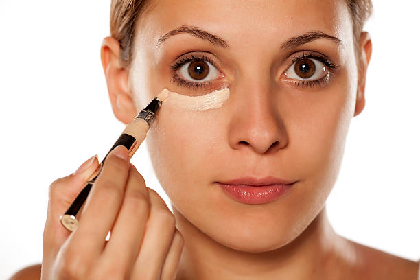 istock young beautiful woman applied concealer under the eyes 628835450