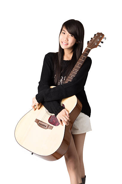 Female guitarist portrait covering half of her face with fretboard acoustic guitar
