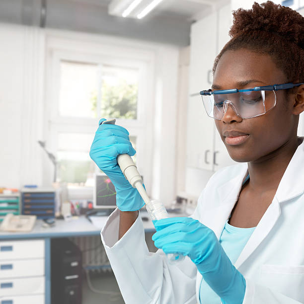 femme scientifique afro-américaine ou étudiante diplômée travaillant - scientist research test tube lab coat photos et images de collection