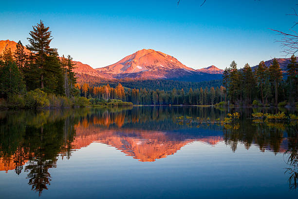 マンザニタ湖を反射したラッセンピークの夕日 - alpenglow ストックフォトと画像