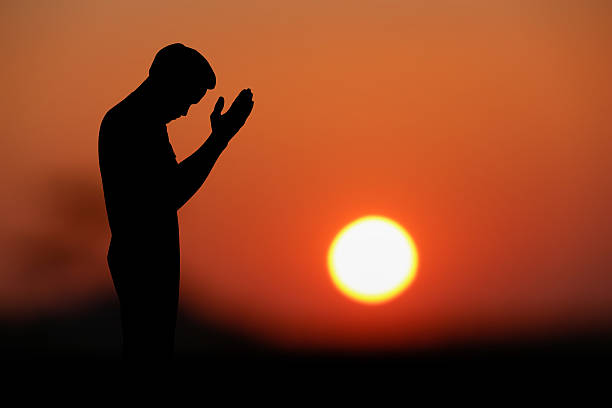 istock islamic prayjng at sunset. 628846624
