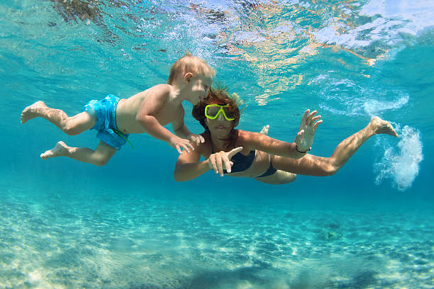 istock Mother with child swim underwater with fun in sea 628847548