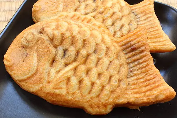 Close-up of Japanese Taiyaki fish-shaped cakes on black plate
