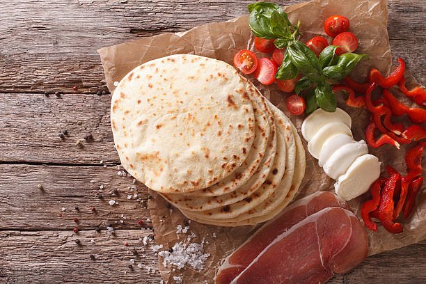 piadina italiana focaccia, prosciutto, formaggio e verdure da vicino. - piadina foto e immagini stock