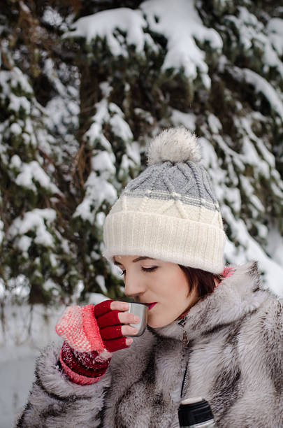 istock brunette girl walking in snow and drinking coffee 628866978