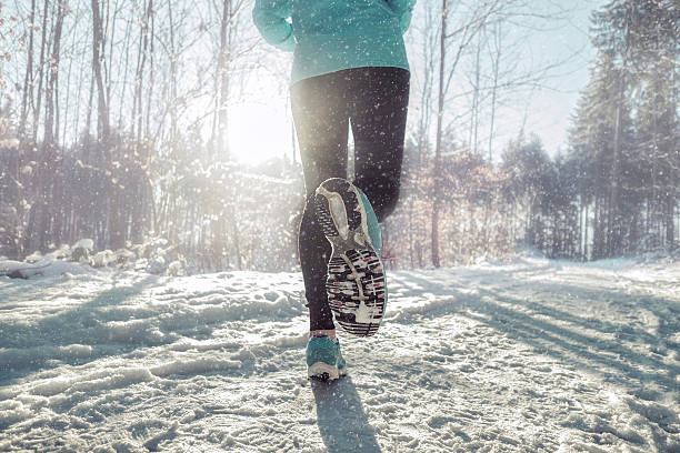 istock Woman Running at snowly winter under sunlight. 628875104