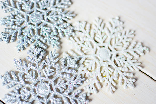 istock Close up of two decorative snowflake on white wooden background. 628877020