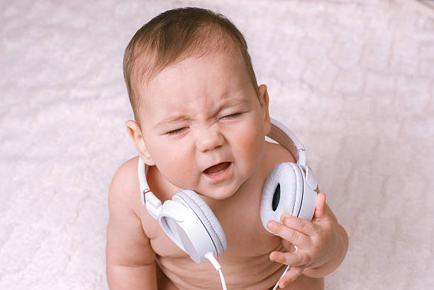 istock Small baby wearing earphones crying 628877360