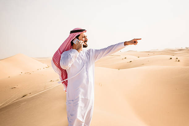 istock arabic sheik on the phone on the desert 628884216