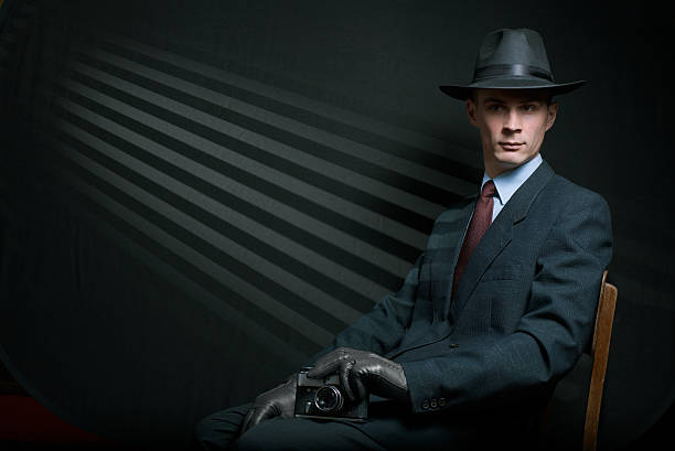 istock Stylish vintage detective posing on a chair 628884282