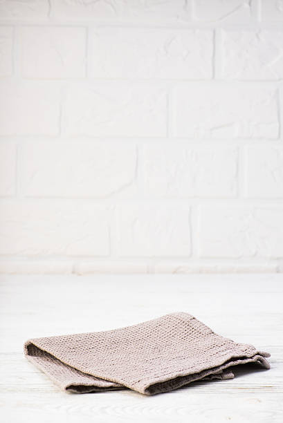 istock Gray napkin isolated on white wooden table. Copy space. Brick 628884306