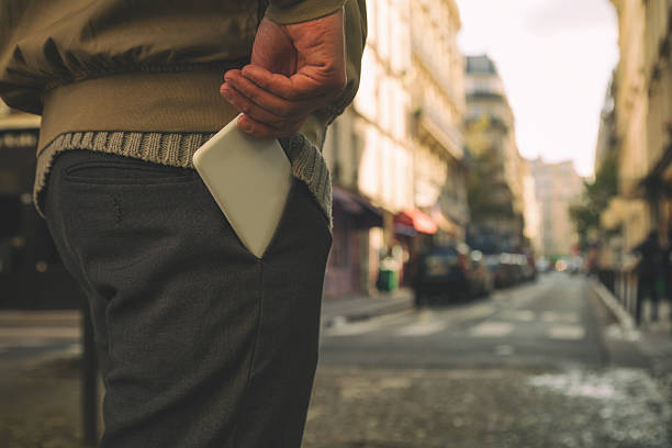 Man holding cellphone in pocket. stock photo