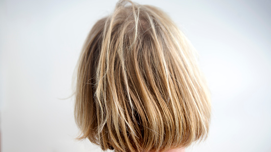 closeup of back of head with uncombed long blond hair